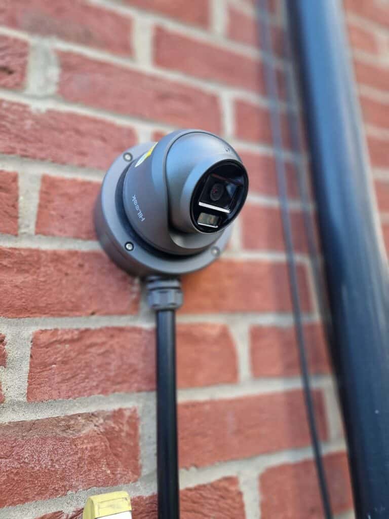 Close-up of a security camera on a brick wall