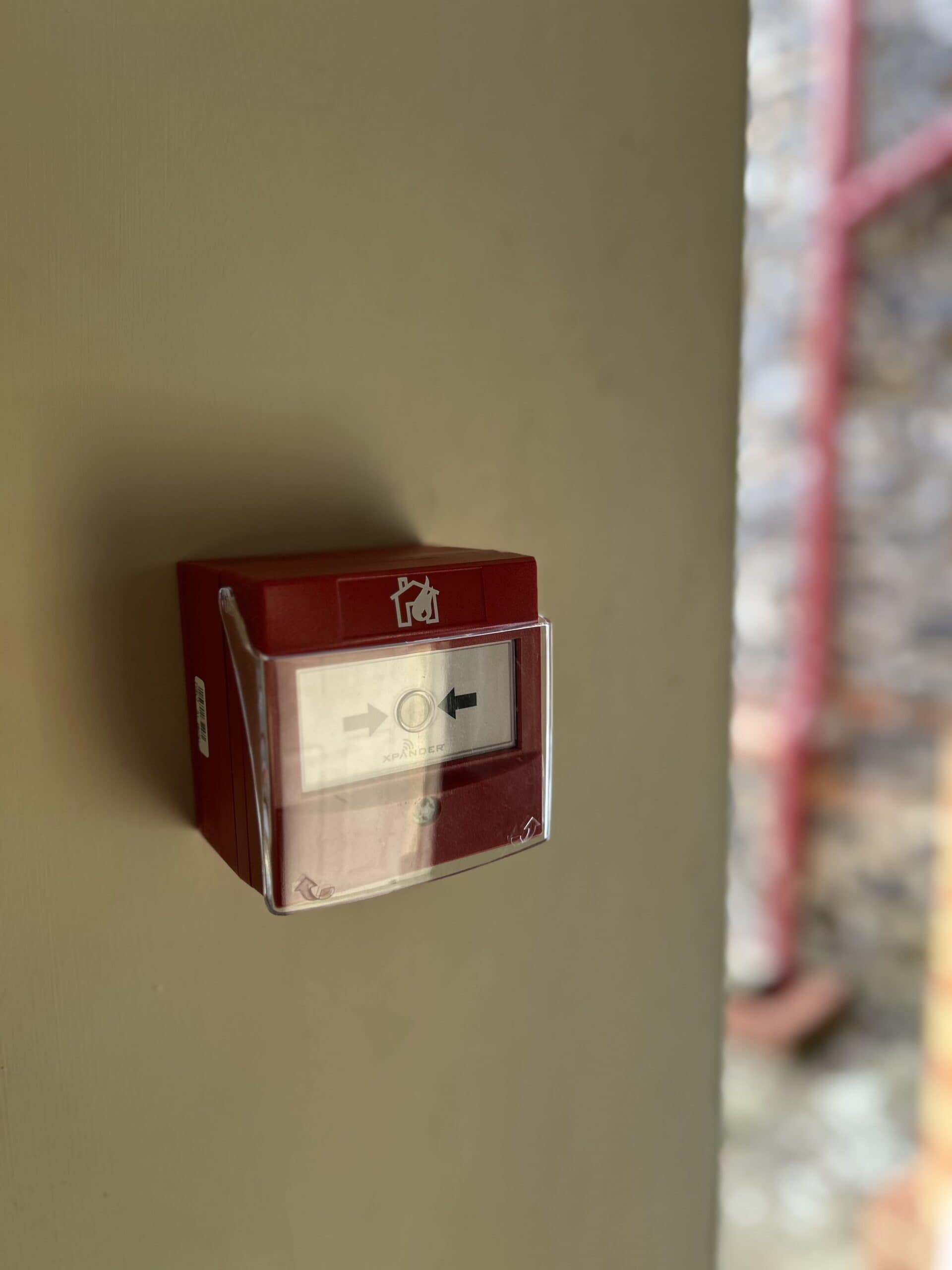 Red fire alarm pull station on wall