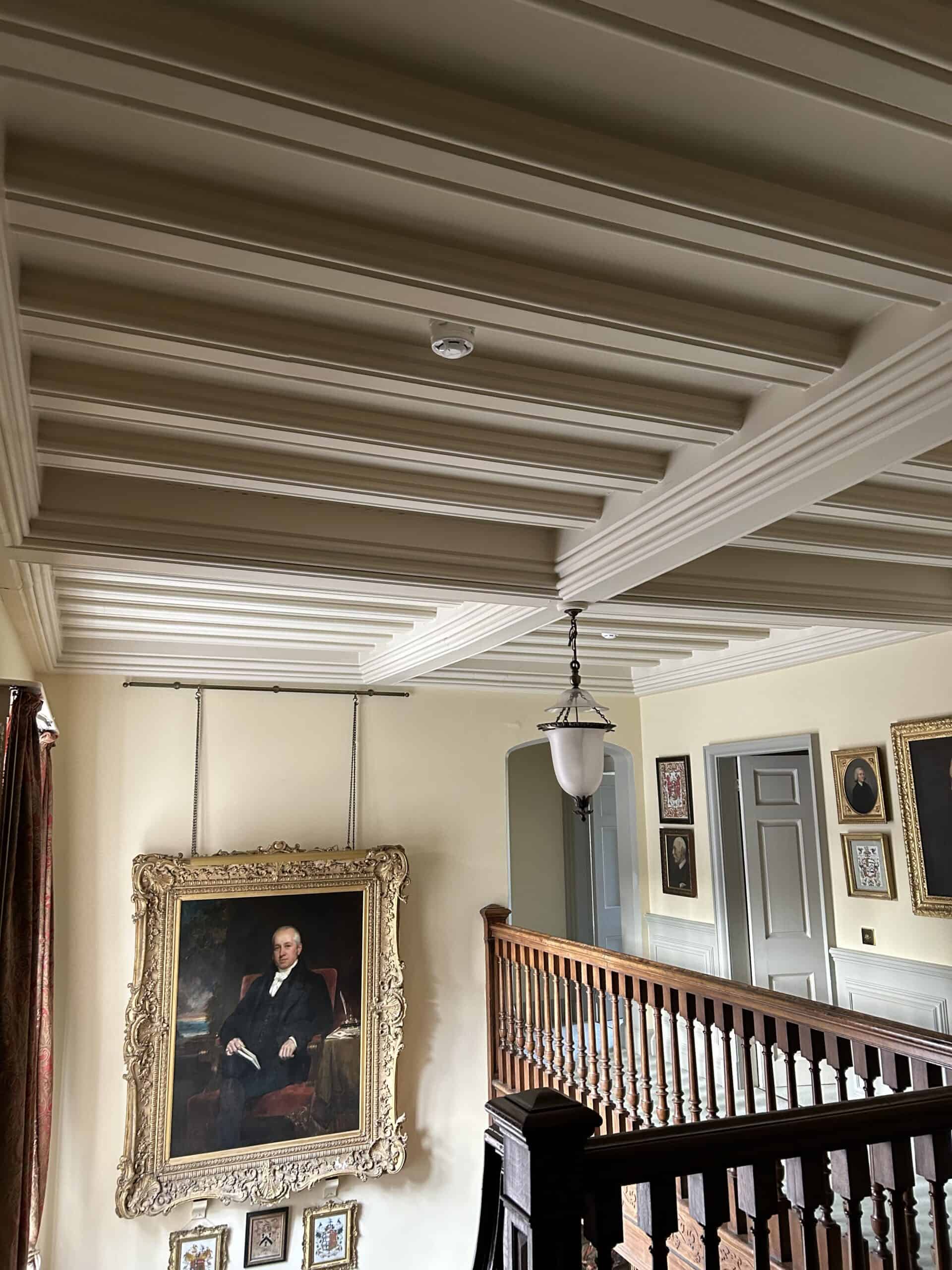 Ceiling with wooden beams and framed portraits