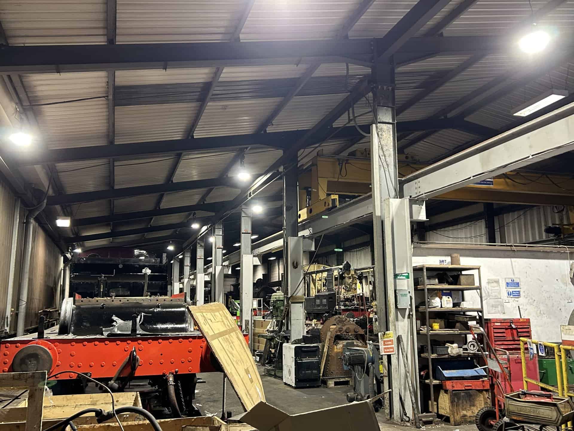 Brightly lit industrial workshop with machinery and tools.