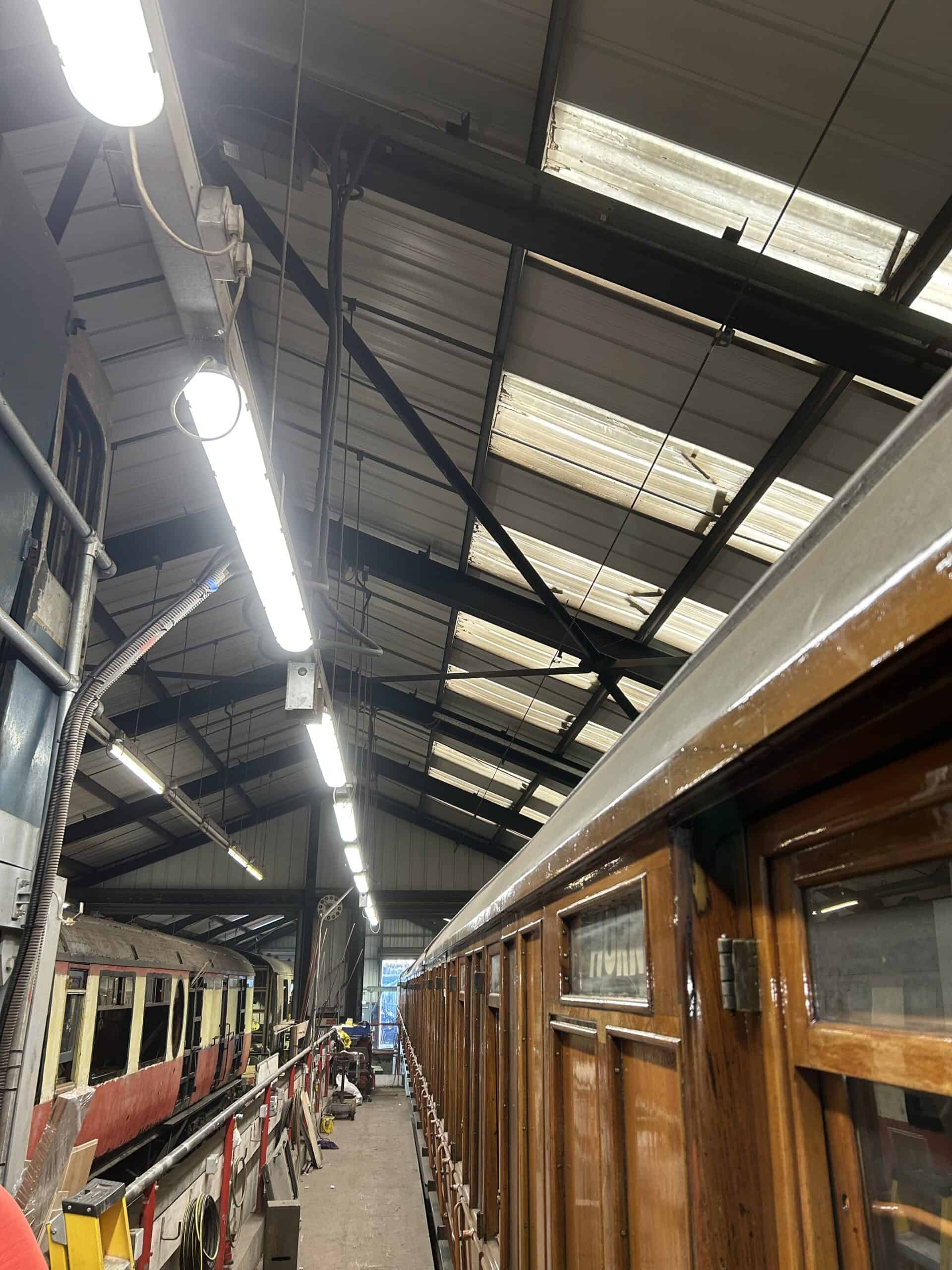 Inside a railway workshop with vintage trains.