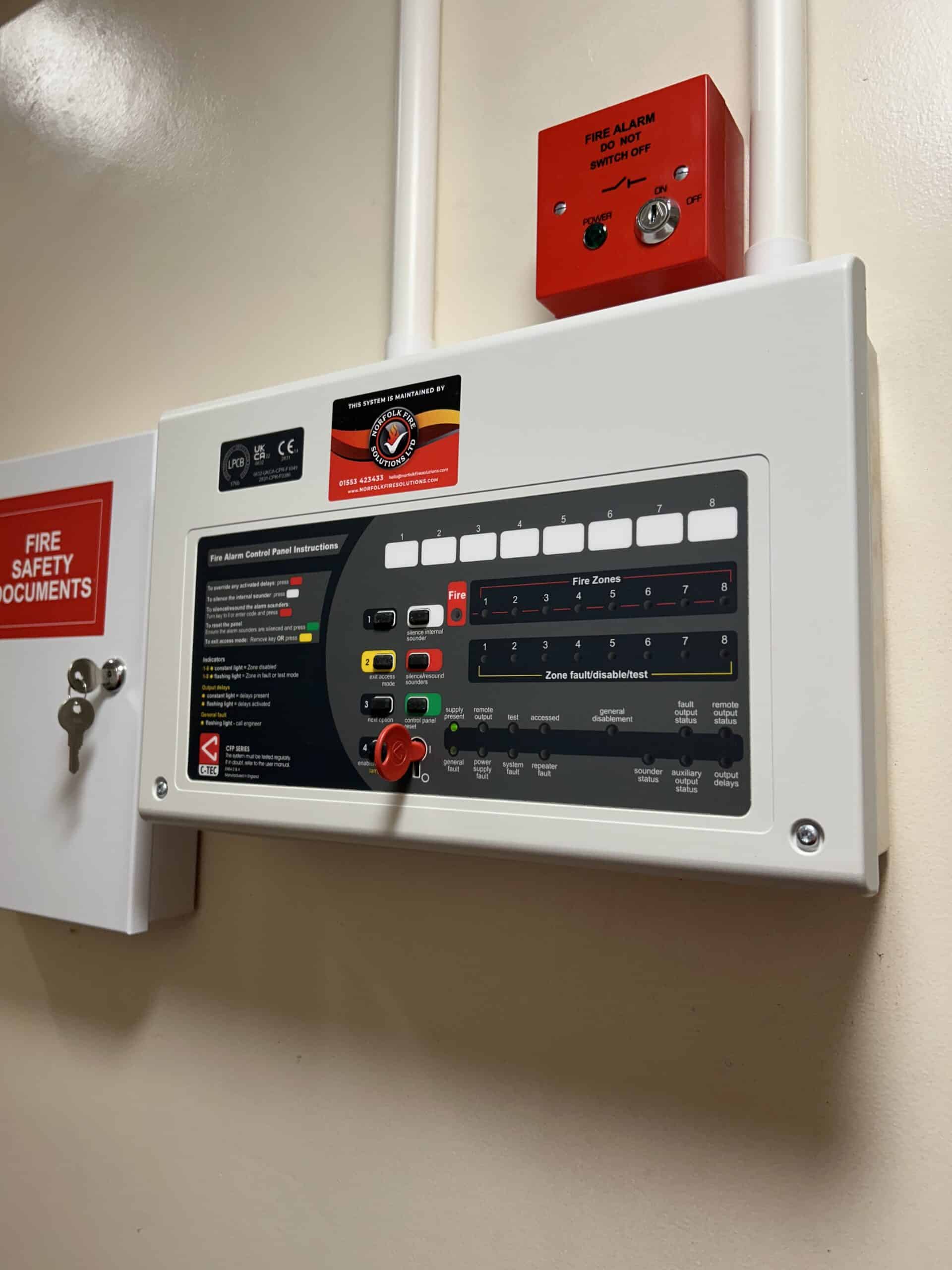 Fire alarm control panel with safety instructions.