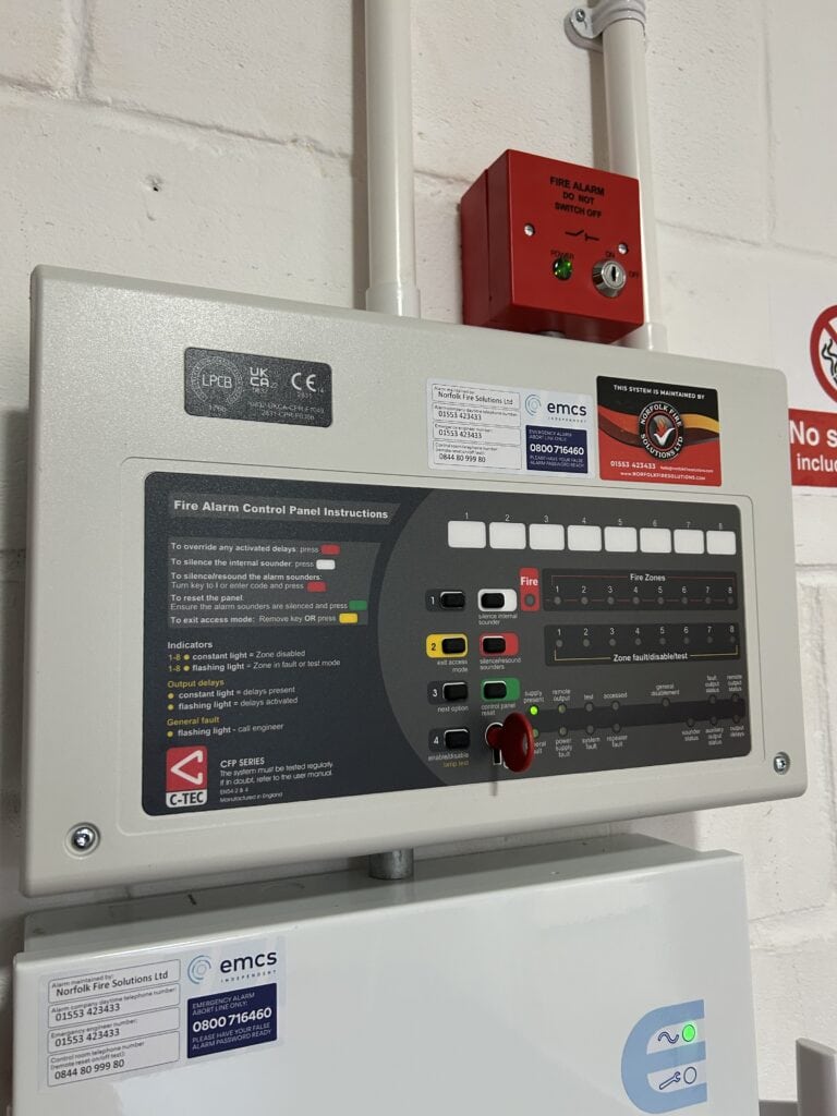 Fire alarm control panel with instructions and indicators.