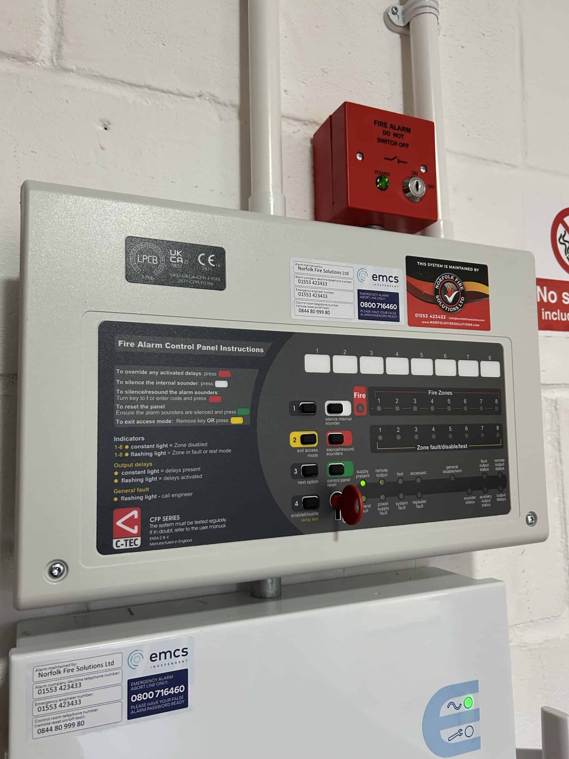Fire alarm control panel with instructions and indicators.