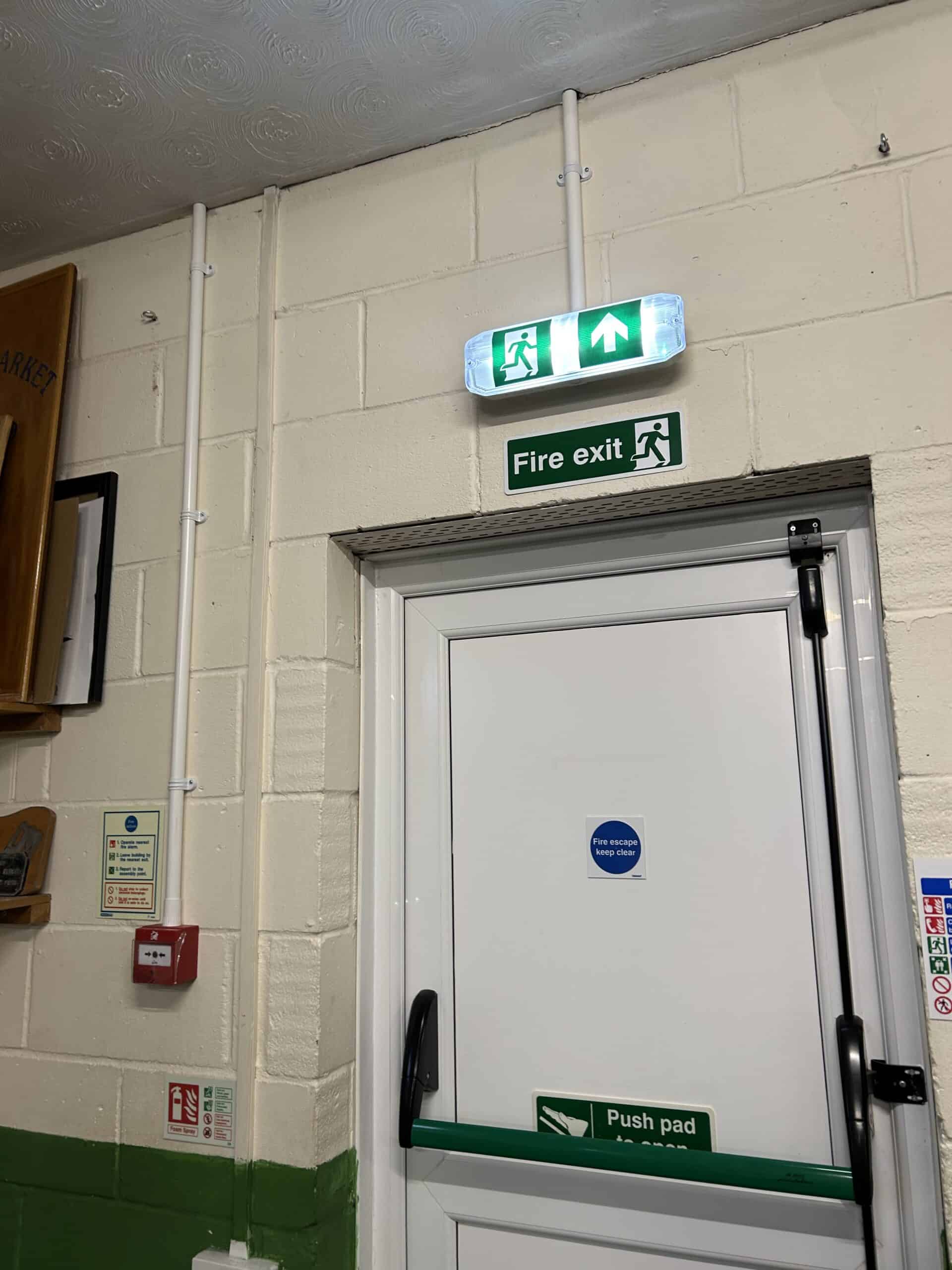 Exit door with fire exit signage and lighting.