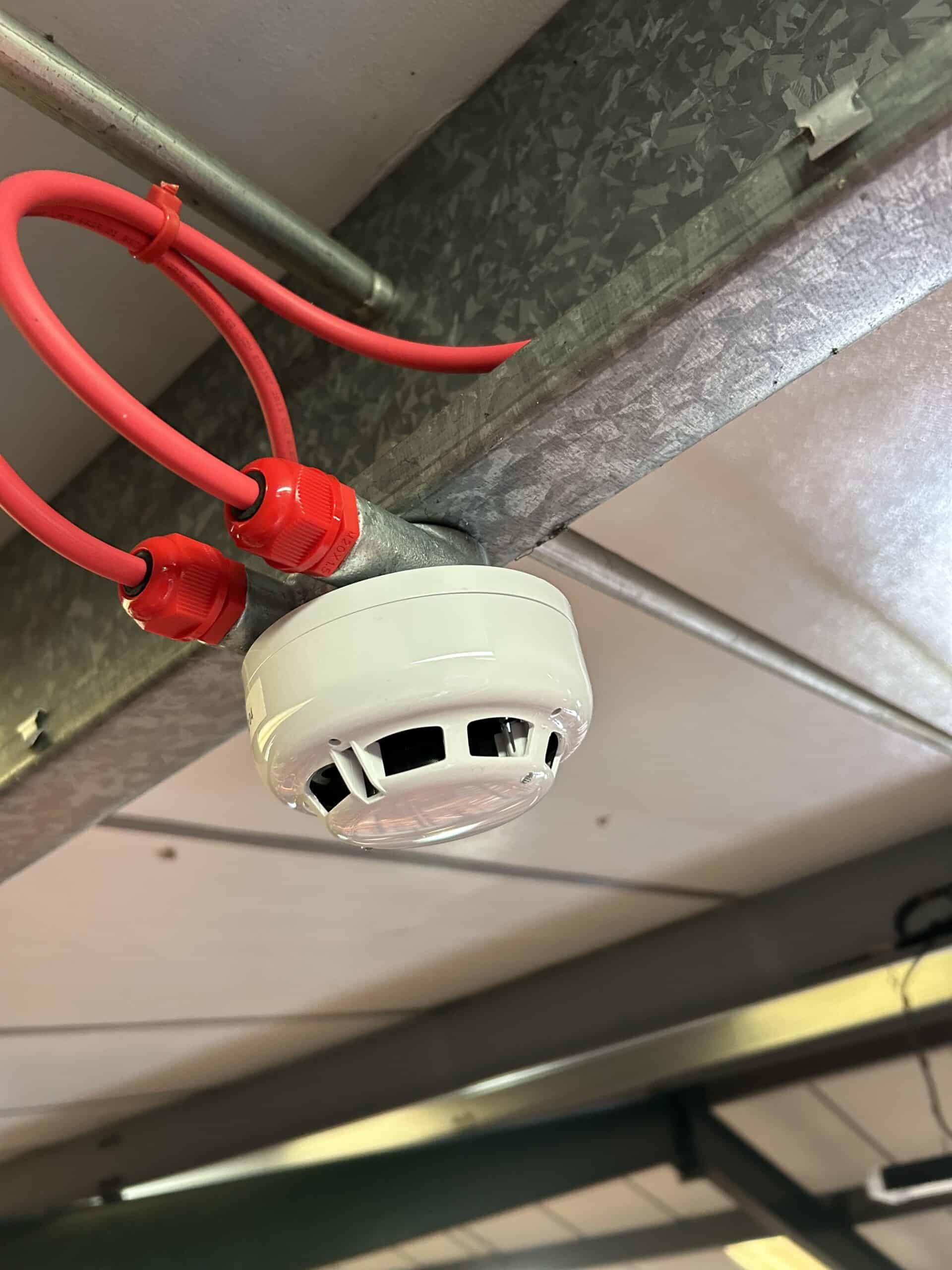 Ceiling-mounted fire alarm with red wires